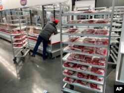 FILE - An employee restocks meats in North Miami, Florida, Jan. 17, 2023.