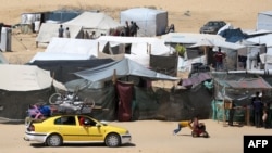 Displaced Palestinians transport their belonging atop a car as they flee to a safer area in Rafah in the southern Gaza Strip, May 9, 2024.
