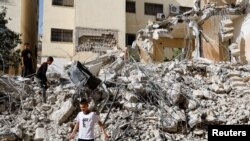 Palestinian children walk amidst the rubble of damaged buildings in the aftermath of an Israeli raid on Jenin camp in the Israeli-occupied West Bank, May 23, 2024. 