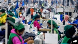 FILE - Garment employees work in a sewing section of the Snowtex Outerwear Ltd. factory in Savar, Bangladesh, Aug. 9, 2021.
