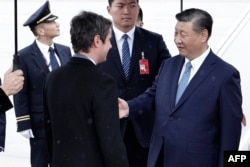 France's Prime Minister Gabriel Attal (L) greets China's President Xi Jinping upon his arrival for an official two-day state visit, at Orly airport, south of Paris on May 5, 2024.