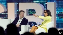 CEO Twitter Elon Musk (tengah) berbincang dengan Linda Yaccarino, kepala periklanan global dan kemitraan NBC, dalam sebuah konferensi di Miami Beach, Florida, 18 April 2023. (Foto: Rebecca Blackwell/AP Photo)