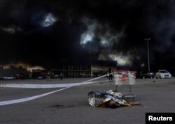 The body of a person killed in a Russian bomb attack, lies covered on the ground at the site of a household item shopping mall which was hit in the Russian air strike in Kharkiv, Ukraine, May 25, 2024.