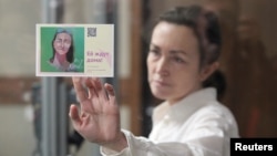 FILE - Russian-American journalist for Radio Free Europe/Radio Liberty Alsu Kurmasheva holds a card reading "She's expected home" as she attends a court hearing in Kazan, Russia, April 1, 2024. 