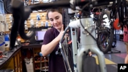 FILE - Mechanic Lizzy Thomson works at University Bicycles in Boulder, Colo., April 30, 2024.