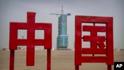 The Shenzhou-16 spacecraft sits atop a Long March rocket covered on a launch pad near characters reading "China" at the Jiuquan Satellite Launch Center in northwest China, May 29, 2023.