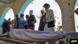 আত্মঘাতী বোমা হামলায় নিহত একজনের চারধারে দাঁড়িয়ে আত্মীয়-পরিজনরা, কান্দাহারে এক মসজিদে শেষকৃত্যের সময়। ২১ মার্চ, ২০২৪।