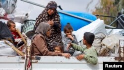 Palestinians ride on a vehicle as they flee Rafah after Israeli forces launched a ground and air operation in the eastern part of the southern Gaza City, May 13, 2024.