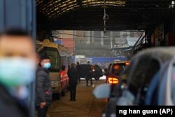 Konvoi kendaraan yang membawa tim peneliti WHO memasuki Pasar Makanan Laut Huanan dalam kunjungan tiga hari di Wuhan, China tengah, 31 Januari 2021. (Foto: Ng Han Guan/AP Photo)