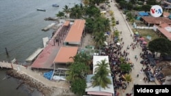 Imagen aérea que muestra a migrantes gestionando su embarque en el puerto de Necoclí rumbo a la selva del Darién. 