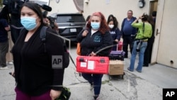 Funcionarios del servicio público de Operaciones de Emergencias del Condado Los Ángeles salen de la Iglesia católica croata de San Antonio, en Los Ángeles, tras evaluar a varios migrantes alojados en la ciudad el miércoles 14 de junio de 2023.