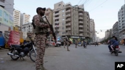 FILE - Paramilitary soldiers stand guard along road side to ensure security in Karachi, Pakistan, April 9, 2024.