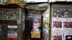 FILE - A Bangladeshi woman holds a portrait of a relative who was a victim of the Rana Plaza factory collapse, at the site of the accident on the fifth anniversary in Savar, near Dhaka, Bangladesh, April 24, 2018. The tragedy killed 1,134 people.