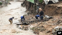 FILE - Men salvage parts from their destroyed home following heavy rains caused by Cyclone Freddy in Blantyre, southern Malawi, March 15, 2023. 