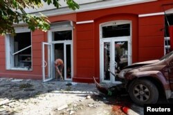 A man cleans at the site of a Russian missile strike in Chernihiv, Ukraine, Aug. 19, 2023.
