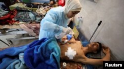 A Palestinian man who was wounded in Israeli fire while waiting for aid, according to health officials, lies on a bed at al Shifa hospital, amid the ongoing conflict between Israel and Hamas, in Gaza City, March 1, 2024. 