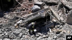 A civil defense worker inspects a destroyed house that was hit by an Israeli airstrike, in Chebaa, a Lebanese town near the border with Israel, south Lebanon, June 26, 2024.