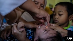 FILE - A health worker gives a polio vaccine to a child in Bogor, West Java, Indonesia, on April 3, 2023. 