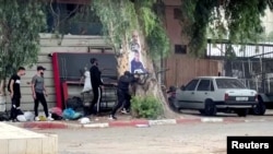 Seorang pria bersenjata Palestina menembakkan senjata saat bentrokan dengan pasukan Israel dalam penggerebekan di Jenin, di Tepi Barat yang diduduki Israel pada 19 Juni 2023. (REUTERS/Raneen Sawafta-videograb)