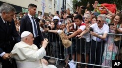 Pope Francis waves to the crowd as he arrives for a meeting with the Portugal's Prime Minister Antonio Costa in Lisbon, Aug. 2, 2023.