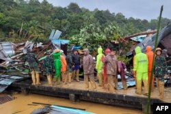Tim SAR memeriksa kerusakan akibat tanah longsor di kepulauan Natuna, 7 Maret 2023. (Handout / Kemenkominfo Natuna / AFP)