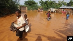 FILE - Children flee floodwaters that wreaked havoc at Mororo, at the border of Tana River and Garissa counties, Kenya, April 28, 2024. 
