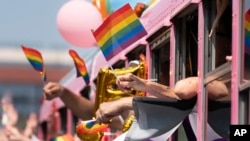 FILE - Parade participants wave to spectators during the Nashville Pride Parade June 24, 2023, in Nashville, Tenn. 