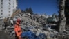 A rescuer stands in front of rubble near the site where Aleyna Olmez, 17, was rescued from a collapsed building, 248 hours after the earthquake which struck parts of Turkey and Syria, in Kahramanmaras, Feb. 16, 2023. 