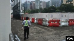 A carnival worker guards the perimeter of a closed-off soccer field which traditionally had been used for Tiananmen Square crackdown commemorations, at Victoria Park, Hong Kong, June 4, 2024. (Cindy Sui/VOA)