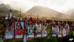 FILE — Photos are displayed at a memorial for victims of the August 2023 wildfire, above the Lahaina Bypass highway in Lahaina, Hawaii, Dec. 6, 2023. The last of the 100 known victims of the wildfire was identified Friday as Lydia Coloma, 70.