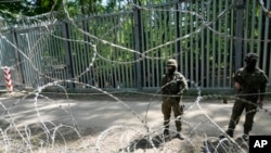 Polish troops guard the metal barrier border with Belarus, in Bialowieza Forest, May 29, 2024. Poland says neighboring Belarus and its main supporter Russia are behind a surging push by migrants in Belarus toward the European Union.
