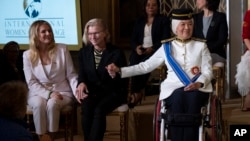 Polish journalist Bianka Zalewska, left, Ukrainian medic Yuliia Paievska, center, and Malaysian Senator Datuk Ras Adiba Radzi hold hands during the International Women of Courage award ceremony at the White House in Washington, March 8, 2023. All three are award recipients.