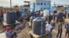 Palestinians queue to collect drinking water from a water treatment station in the central Gaza Strip to distribute to displaced people at shelters, in Deir al Balah, Gaza Strip, Oct. 27, 2023.