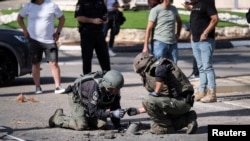 Israeli security personnel check the remains of a rocket in Shlomi, northern Israel, April 6, 2023.