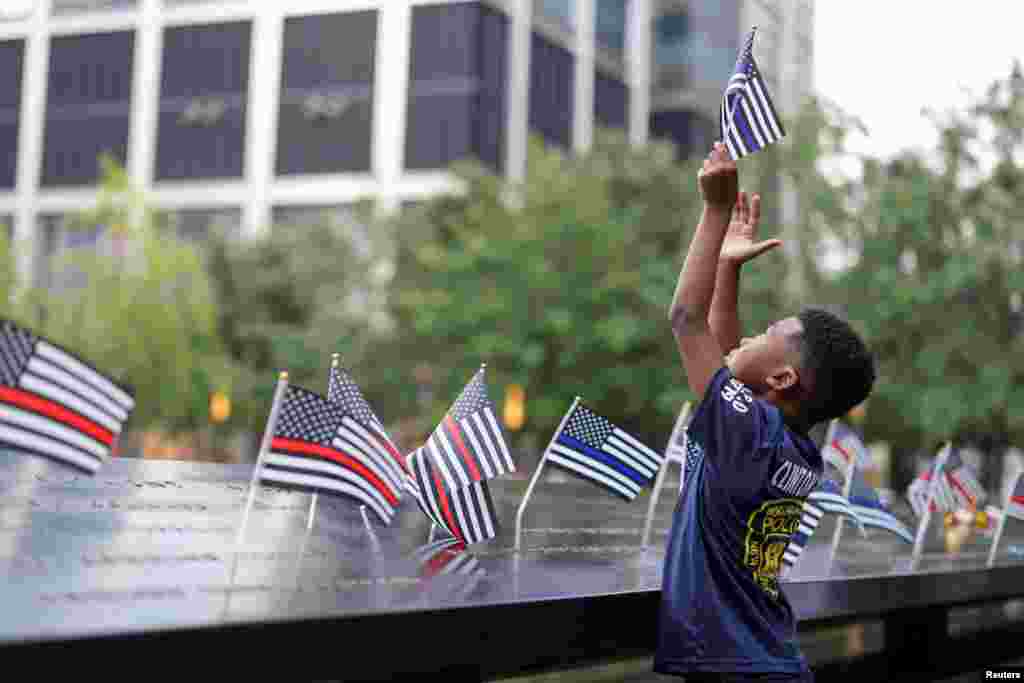 A person holds a flag on the 22nd anniversary of the September 11, 2001 attacks on the World Trade Center at the National September 11 Memorial & Museum, in New York City.