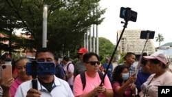 People film with their mobile devices at Plaza Libertad in San Salvador, June 24, 2023. In April, the President of El Salvador’s congress Ernesto Castro announced he would open the legislative body to YouTubers and social media content creators.
