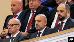FILE - Milan Radoicic (C), Serb List leader Goran Rakic (L) and former mayor of the Serb part of the ethnically divided town of Mitrovica Milan Radojevic attend a session of parliament, in Belgrade, Feb. 2, 2023. 