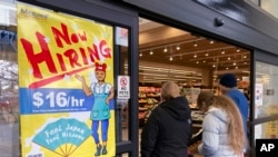 FILE - A hiring sign is displayed at a grocery store in Arlington Heights, Illinois,, Jan. 13, 2023. A strong job market has helped fuel the inflation pressures that have led the Federal Reserve to keep raising interest rates.