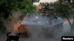 资料照片：乌军第93机械化旅的军人在巴赫穆特附近前线驾驶一辆配备高射炮的装甲车。(2024年5月23日) 