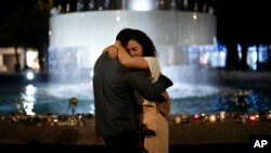 A couple hugs next to candles lighted in honor of victims of the Hamas attacks during a vigil at the Dizengoff square in central Tel Aviv, Israel, Oct. 13, 2023