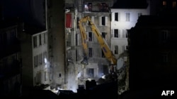 An excavator moves rubble at 'rue Tivoli' after a building collapsed in the same street, in Marseille, southern France, on April 9, 2023. 