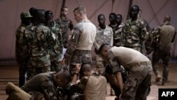 Dans un hangar de la base française projetée de Niamey, les 70 parachutistes – une quarantaine de légionnaires et trente Nigériens – préparent et vérifient leur matériel.