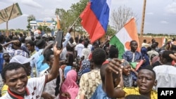 Supporters of Niger's coup leaders hold a Russian flag as they gather for a demonstration in Niamey on Aug. 11, 2023, near a French airbase in Niger. 