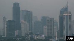 Gedung-gedung pencakar langit di Jakarta berselimut kabut asap akibat polusi udara, 23 Agustus 2023. (Yasuyoshi CHIBA / AFP)