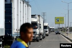 FILE - Trucks head to the Egyptian side of the border to be loaded with aid that will be delivered to Palestinians in Gaza, in Rafah in the southern Gaza Strip, Oct. 21, 2023.