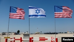 Bendera Israel dan Amerika berdiri selama gladi bersih terakhir upacara penyambutan Presiden AS Joe Biden menjelang kunjungannya ke Israel, di bandara Internasional Ben Gurion, di Lod dekat Tel Aviv, Israel, 12 Juli 2022. (Foto: REUTERS/Amir Cohen)