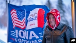 FILE - A man stands next to a flag that reads "Iowa for Trump" outside the the Machine Shed in Urbandale, Iowa, Jan. 11, 2024. 