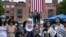People speak to the press as they gather at an encampment to support the people of Palestine during a protest at George Washington University, May 6, 2024, in Washington.