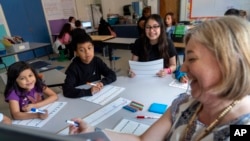 Fifth grade students attend a math lesson with teacher Jana Lamontagne, right, during class at Mount Vernon Community School, in Alexandria, Va., May 1, 2024. 