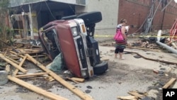 A car lies on its side after being knocked over during a tornado that tore through downtown Sulphur, Oklahoma, April 28, 2024.